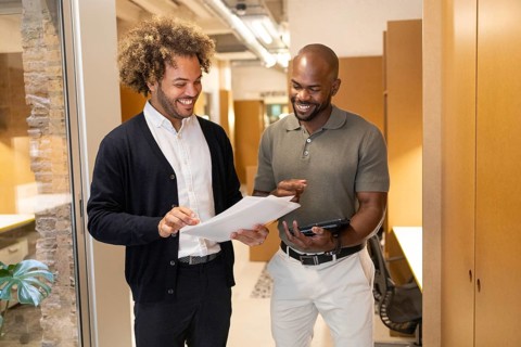 Two diverse professionals engage in a discussion at a vibrant coworking space in Barcelona, sharing