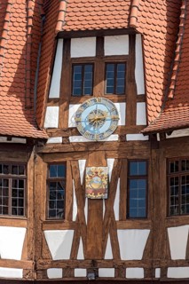 Clock and town coat of arms on façade between beams of half-timbering, old town hall, late medieval