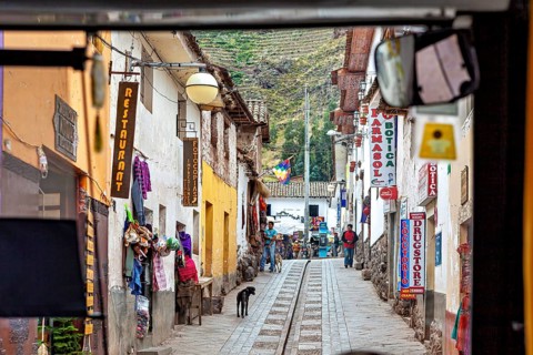 View of a narrow street with colorful shops and restaurants in the Andes, the town of Ollantaytambo