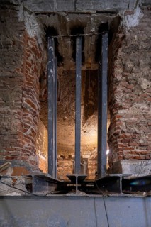 Exposed steel beams integrate with rough brickwork, highlighting architectural elements of a
