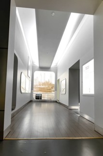 A bright, minimalist interior with high ceilings and large windows that let in natural light,