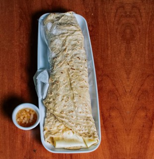 Top view of Nicaraguan Quesillo on a plate served on wooden table. Delicious traditional Nicaraguan