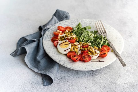 A nutritious keto lunch featuring boiled eggs, fresh rocket, cherry tomatoes, canned green peas,