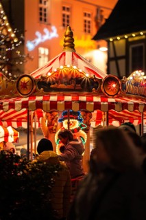 Lively Christmas market with a colourfully illuminated carousel in a festive atmosphere, Christmas