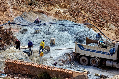 People work with a truck at a construction site in hilly terrain, the silver mines near Potosi on
