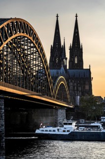 Silhouettes of the cathedral in late sunlight, freighter on the Rhine, view of Cologne Cathedral