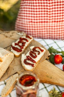 A cozy scene of canape preparation featuring fresh bread with cream cheese and sun-dried tomatoes,