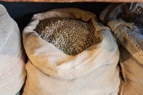 Burlap sacks filled with raw coffee beans are ready for the roasting process in this artisanal