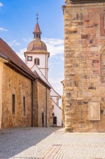 Combination of church and brick buildings with bell tower under a clear sky, Knittlingen, Germany