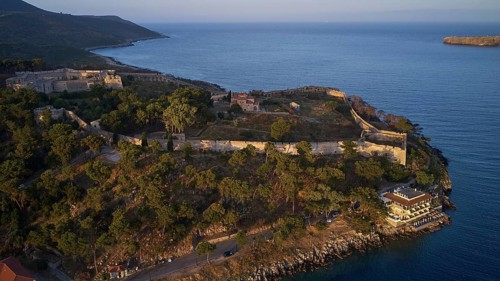 Drone shot, view of a historic fortress on the coast at sunset and calm sea, fortress complex,
