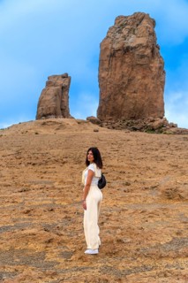Young woman hiking on a trail in a volcanic landscape, exploring the natural beauty of roque nublo