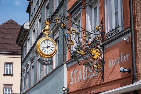 Traditional guild signs for watchmakers, nose sign with an oversized, gold pocket watch with Stauss