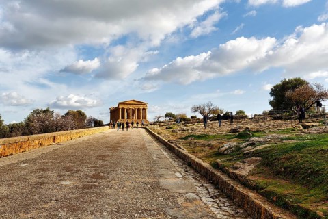 Walkers in front of Concordia Temple, Valley of the Temples, Agrigento, Sicily, Italy