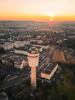 Urban landscape with water tower in the foreground and sunset in the background, Sindelfingen,