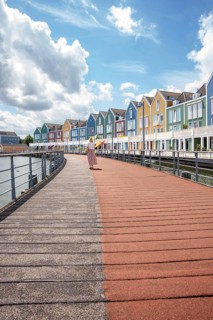 Woman in front of colourful houses by the water, Houten Netherlands