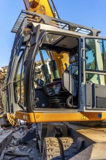 Vertical photo with no people and close-up of an excavator outside a recycling plant