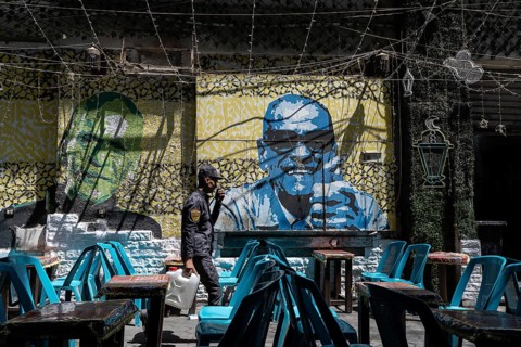 Cairo, Egypt. April 18th 2025. Empty cafe tables and a street art portrait of Naguib Mahfouz in