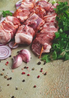 Raw pork meat, on wooden skewers, pickled kebab, with spices and herbs, on the table, top view, no