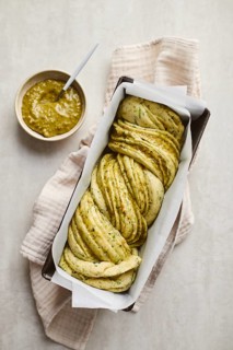 Ready to bake, homemade savoury babka plaited bread loaf flavoured with cheese and pesto, in the