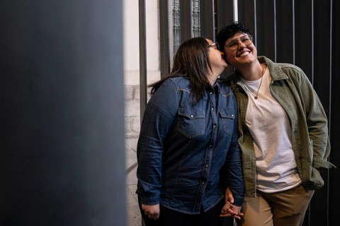 A joyful lesbian couple enjoys a tender moment outdoors. One woman conveys affection to her