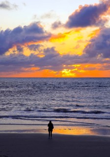 Mudflat landscape with setting sun and a person at the sea, Norderney Island, North Sea, East