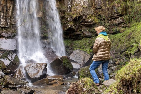 Woman looking at waterfall, Melincourt Waterfalls Nature Reserve, Melincourt, Neath, Wales, United