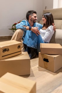 Young couple smiling and enjoying a moment of relaxation while taking a break from unpacking