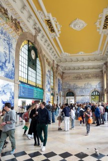 Tour groups viewing historic azulejos tiles, Sao Bento railway station building, city of Porto,