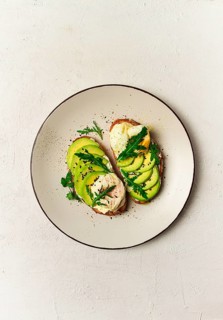 Sandwich with cream cheese, sliced avocado and boiled egg, arugula, on grainy bread, homemade,