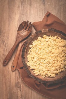 Cooked couscous, in a wooden bowl, top view, no people