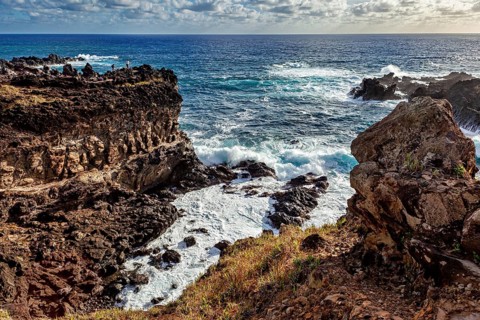 Dramatic coastal cliff with foaming waves against rocks, Easter Island landscape in the Pacific
