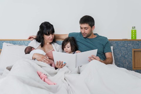 A loving young family shares an intimate moment, with parents and their children, including a big