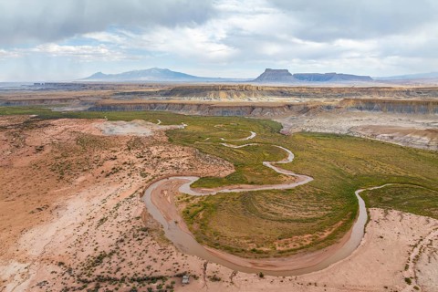 Scenic aerial drone capture of a winding river flowing through the desert landscape near