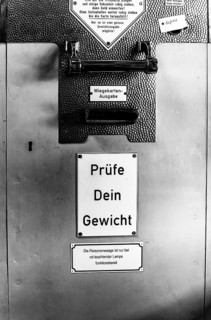 Black and white photograph, old bathroom scales with coin slot, Berlin, Germany