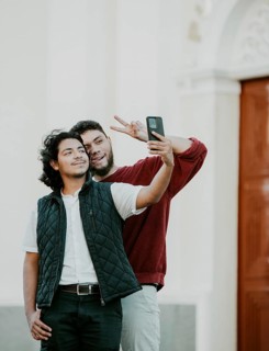 Cheeful friends taking funny selfie on the street. Portrait of funny friends taking a selfie on the