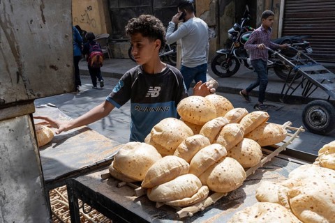 Cairo, Egypt. April 15th 2025. An Egyptian boy collects freshly baked traditional Baladi flat bread