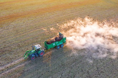 Tractor with manure spreader, agricultural machine used to distribute manure over a field as