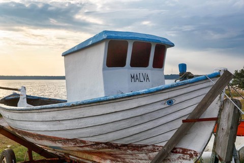 Old white fishing boat with cab, painted evil eye, traditional symbol, protection against