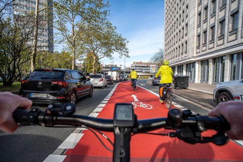 Riding a bike in a bike lane, marked in red to attract the attention of motorists, between 2 lanes,