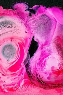 An abstract image showcasing a vivid pink texture with liquids shapes. The vibrant colors and