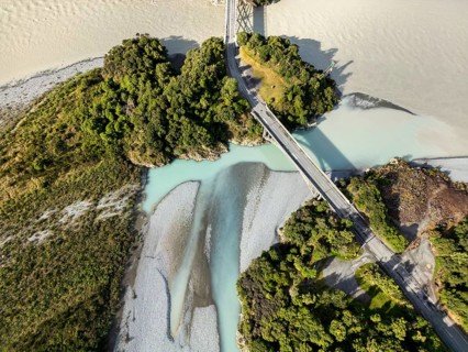 Aerial view captures the scenic landscape of a river and bridge in Canterbury, New Zealand. Lush