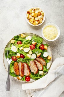 Caesar salad, with duck breast, on a light plate, on a light background, homemade, no people