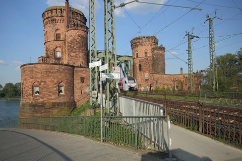 Bicycle path and tracks, train traffic, railroad, bridge pillars, towers, south bridge across the