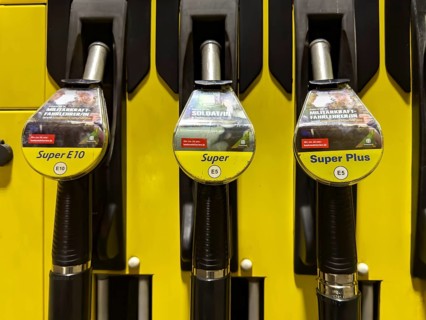 Dispenser at tank system gas station with hooked tank connector labelled with Super E10, Super E5,