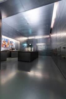 Futuristic exhibition space with metal walls, cool colours and neon lighting presenting works of