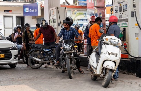 Fuel station attendant refuels vehicles at a petrol pump in Guwahati, India, on March 11, 2026. Oil