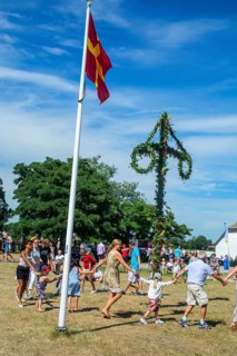 Traditional midsummer celebration with dancing around the maypole at Smygehuk, Smygehamn,