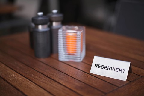 Exterior view, sign RESERVED, reservation for restaurant, eatery, table, candle, salt, pepper,