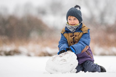 Six years old boy making the snowman
