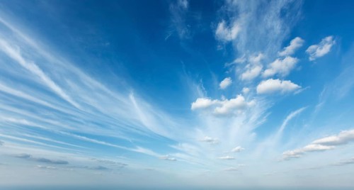 Bright blue sky filled with wispy clouds on a sunny day creates a serene atmosphere perfect for